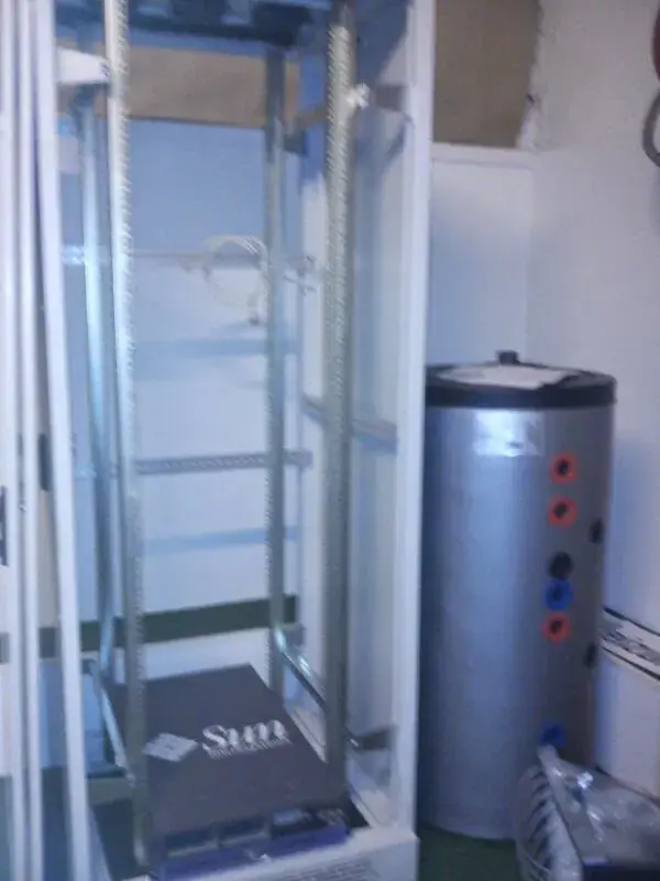 Geöffneter Serverschrank neben einem Wärmespeicher